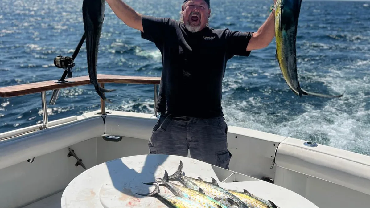 Un pescador con dos dorados en la bañera de un charter de pesca en Nuevo Vallarta