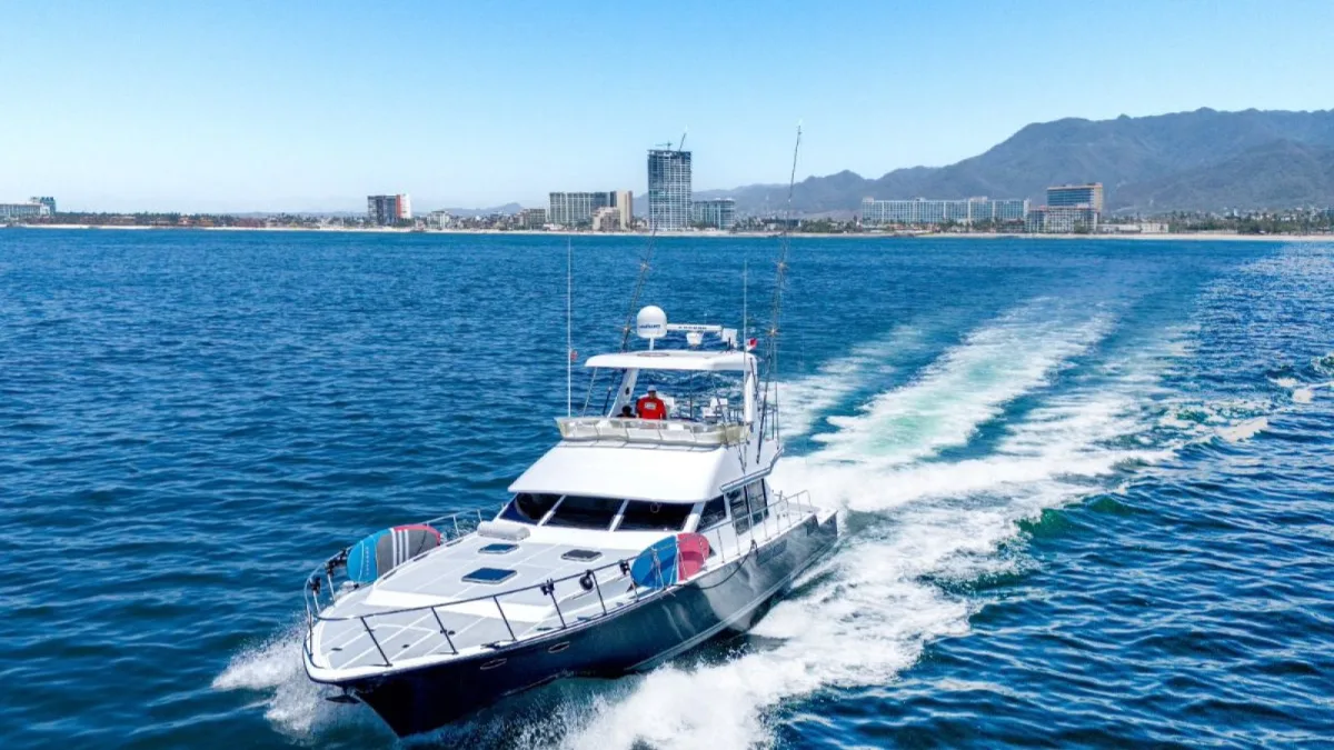 El yate de pesca Mikelson de 60 pies navegando frente a Puerto Vallarta con la ciudad al fondo